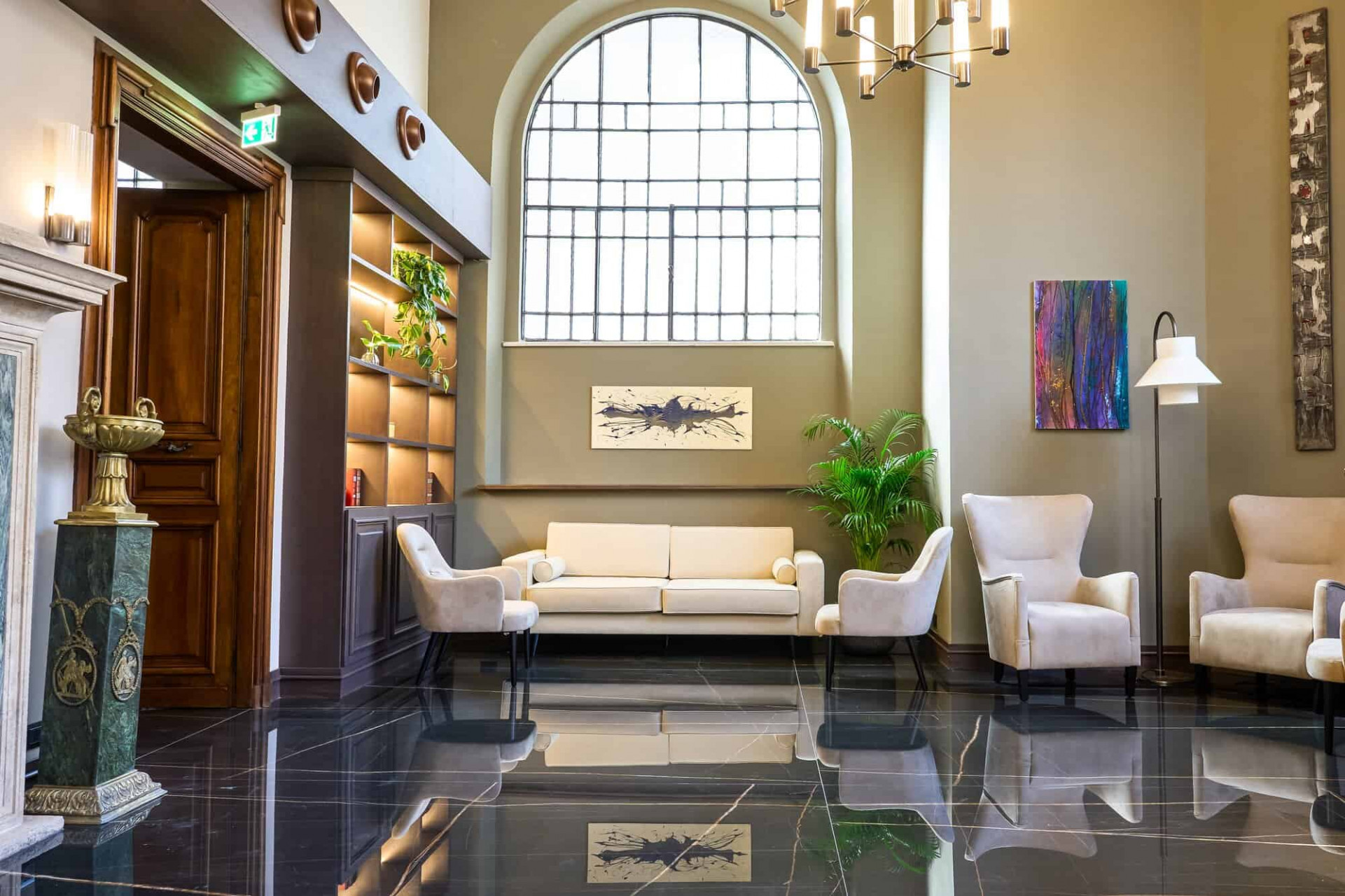 Lobby with white couches, coloful paintings and art piece decorations at Hotel Viminale